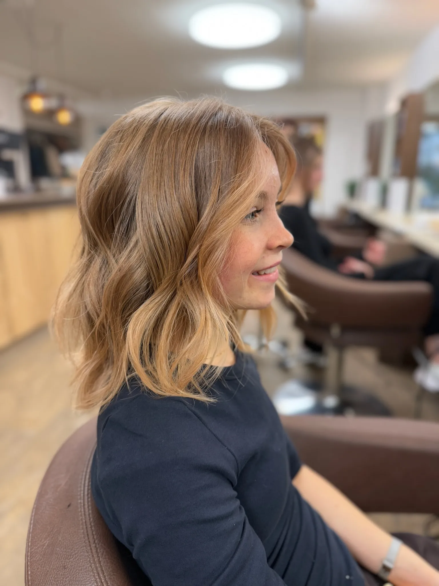 Schulterlange, weich gewellte Haare mit warmen Blondtönen